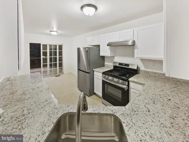 a kitchen with granite countertop a sink and a stove