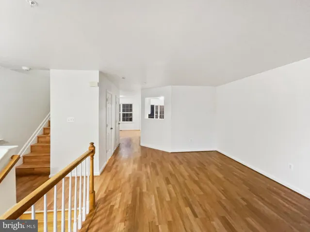 a view of a big room with wooden floor and stairs