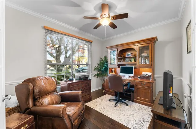 a work room with furniture ceiling fan and a window
