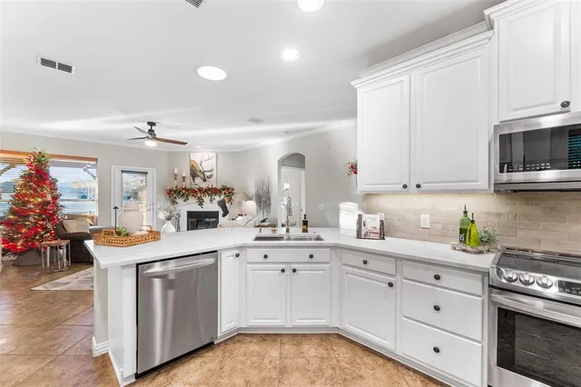 a kitchen with white cabinets and sink