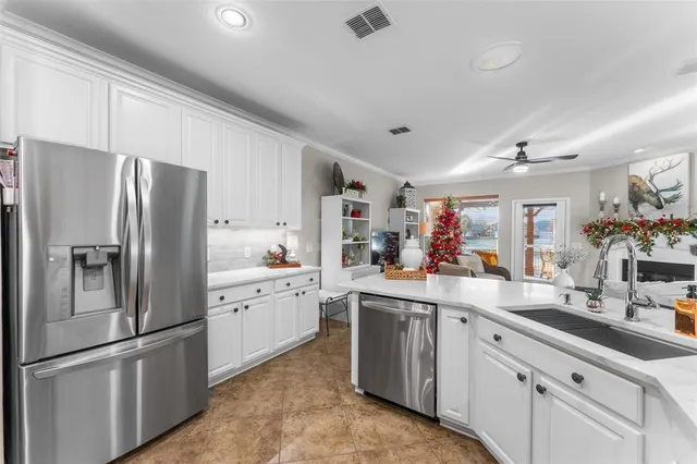 a kitchen with white cabinets and stainless steel appliances