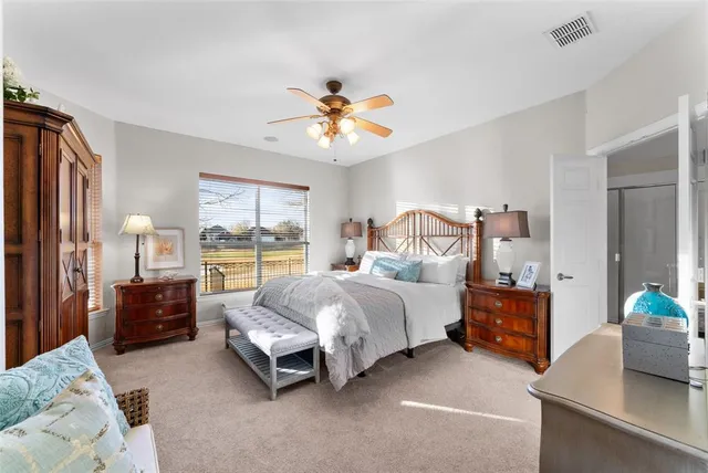 a spacious bedroom with a bed and a chandelier