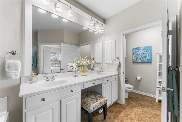 a spacious bathroom with a double vanity sink mirror and toilet