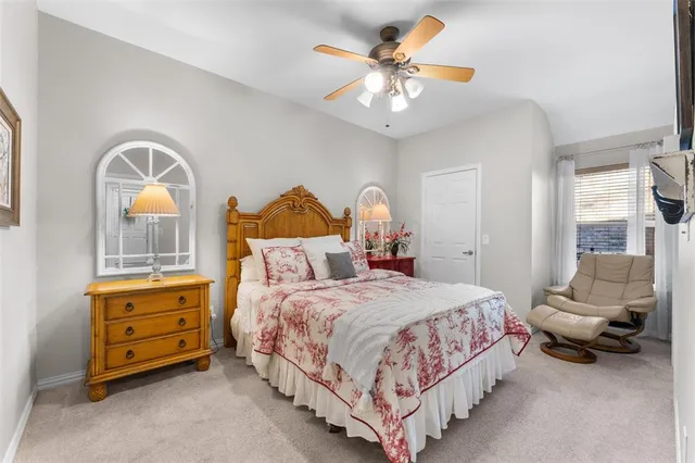 a bedroom with a bed a chandelier and a dresser