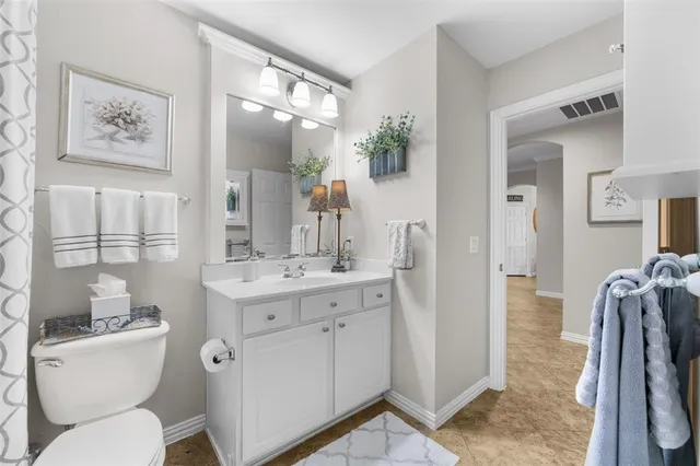 a spacious bathroom with a toilet sink and mirror