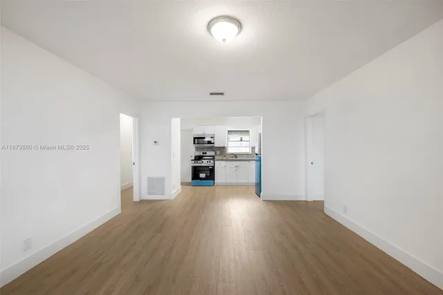 a kitchen with stainless steel appliances granite countertop a refrigerator stove and wooden cabinets