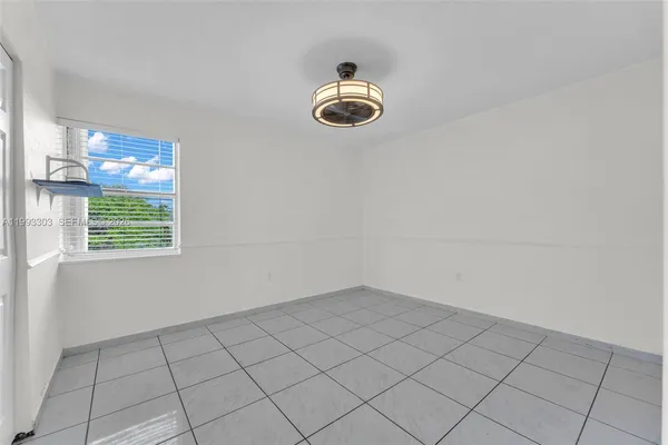 an empty room with windows and fireplace