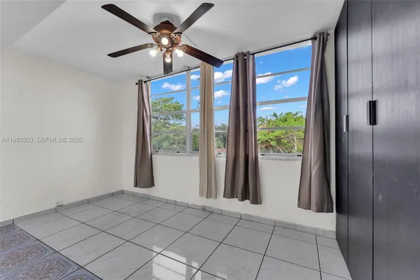 a view of a livingroom with a chandelier fan and windows