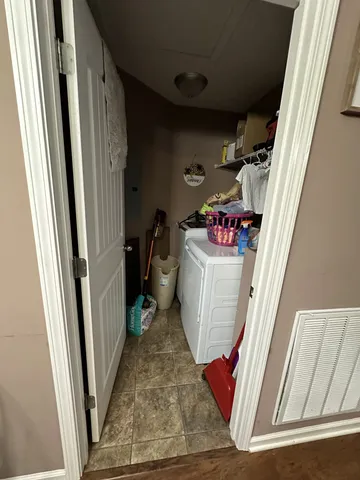 a utility room with wooden floor washer and dryer