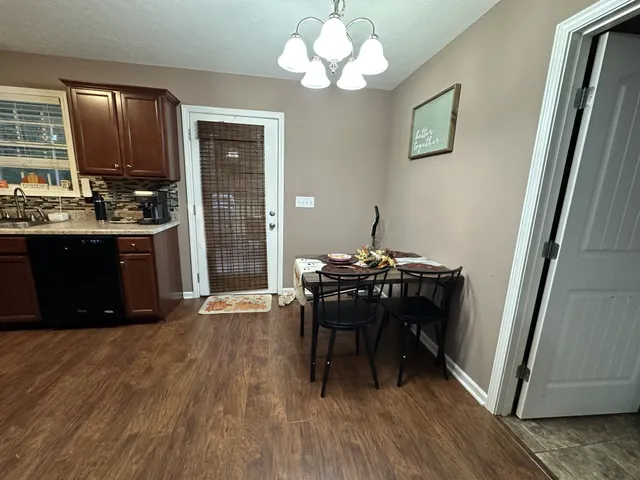 a view of a dining room with furniture a chandelier and wooden floor