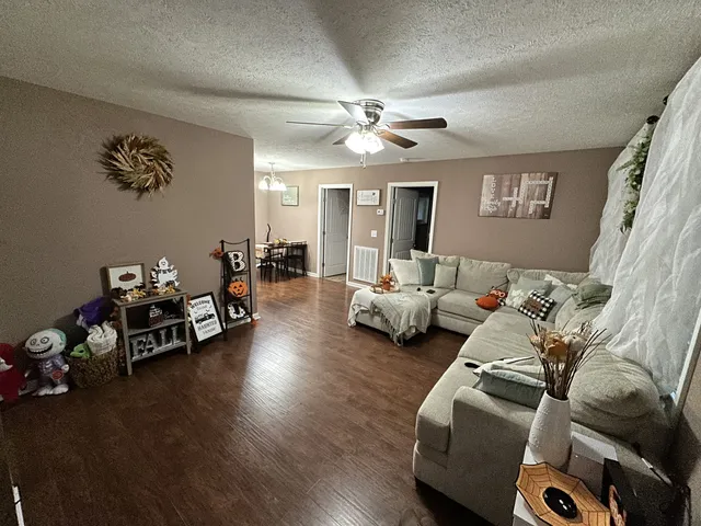 a living room with furniture and a wooden floor