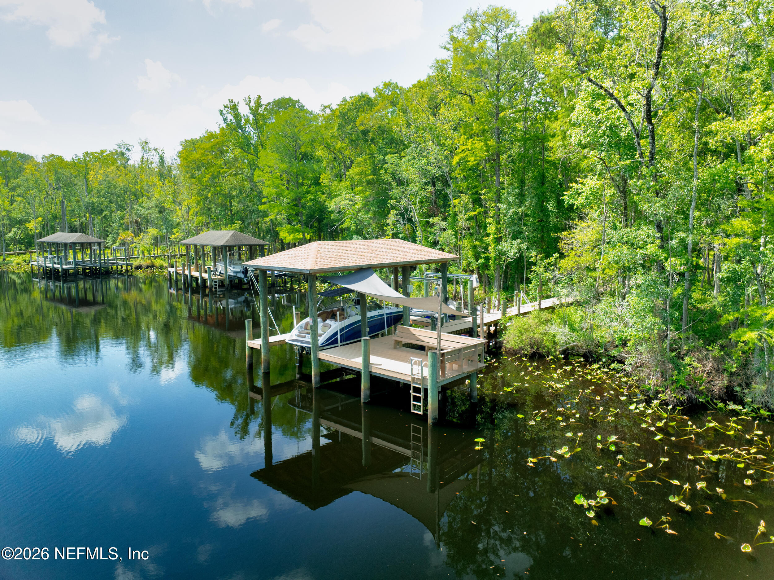 3225 Bishop Estates Road St. Johns, FL 32259 - Photo 65 of 90 a view of a lake with a table and chairs under an umbrella