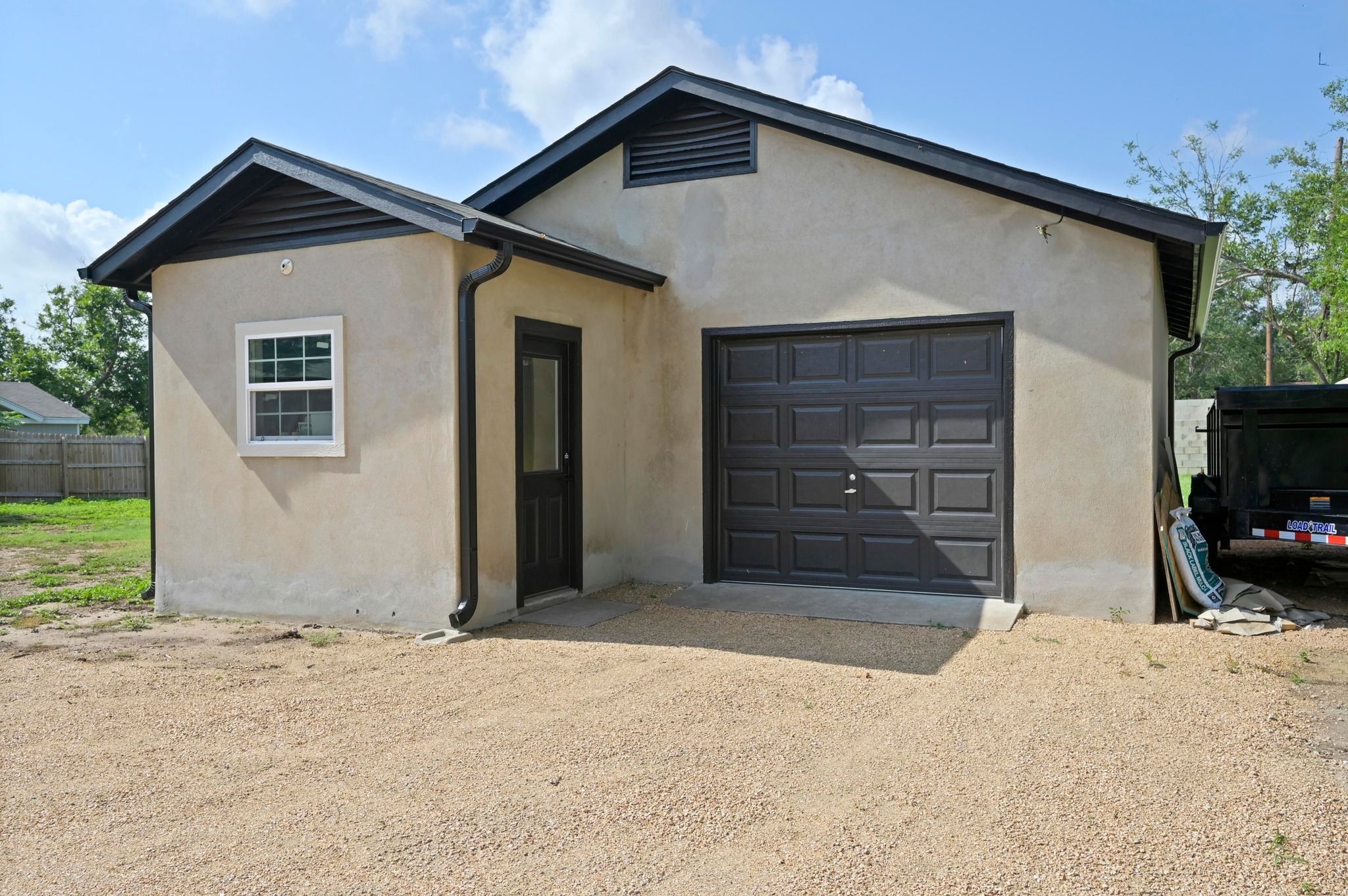 3501 Pecan Springs Road Austin, TX 78723 - Photo 33 of 40 View of front facade featuring stucco siding, dirt driveway, and a garage