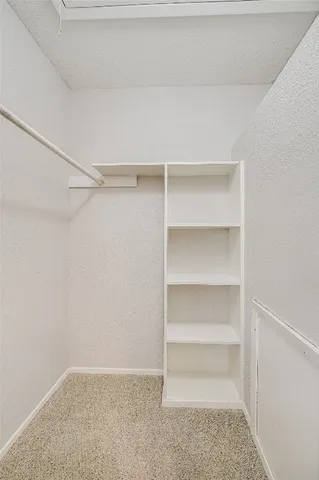 a view of walk in closet with empty racks