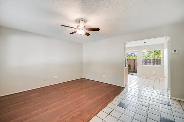 an empty room with windows and fan
