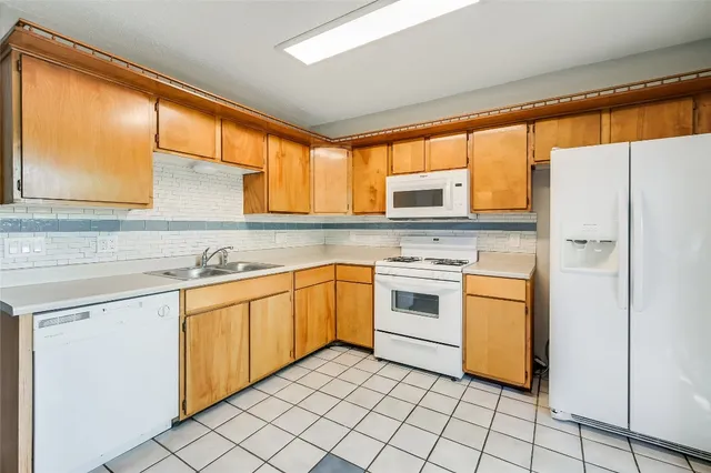 a kitchen with white cabinets and white appliances