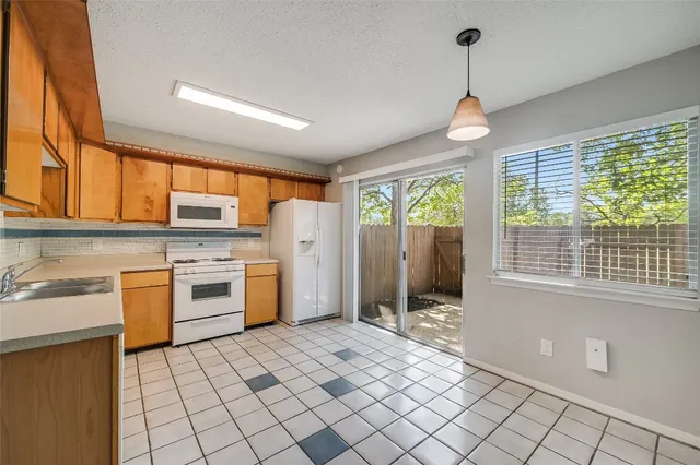 a open kitchen with stainless steel appliances granite countertop a stove a sink and a refrigerator