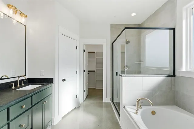 a bathroom with a tub sink and mirror