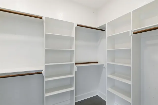 a view of walk in closet with empty racks