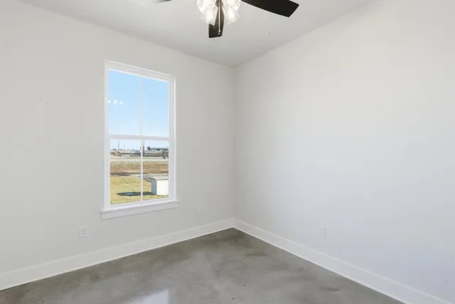 an empty room with closet and a chandelier fan