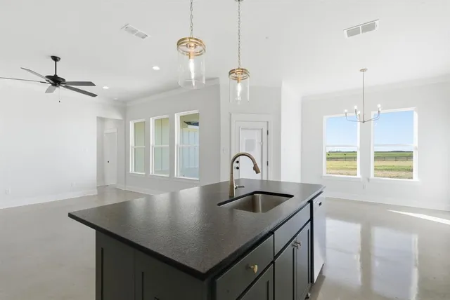 a kitchen with a sink a counter space and a chandelier