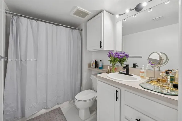 a bathroom with a sink vanity mirror and toilet