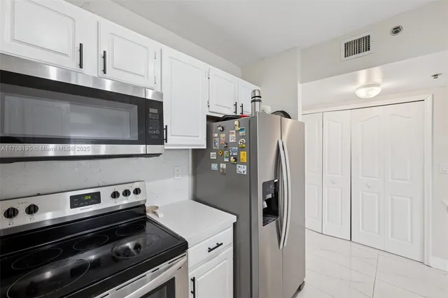 a kitchen with stainless steel appliances a refrigerator a stove and cabinets