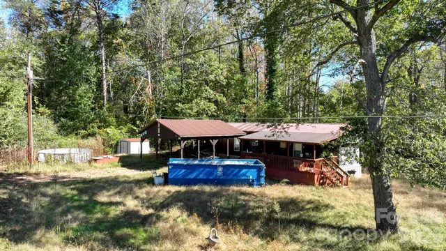 a view of house with roof deck and couches with wooden fence