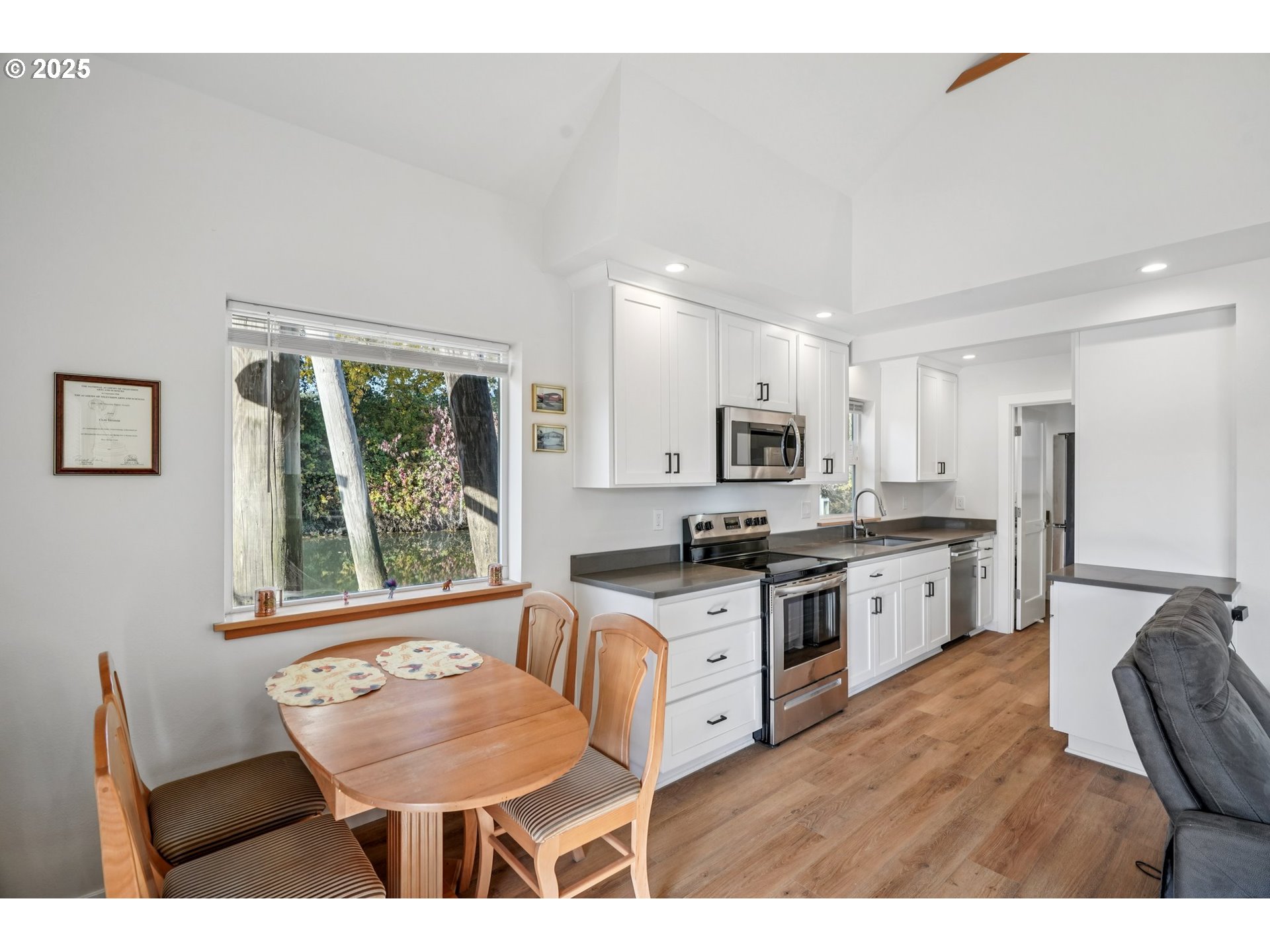 34326 Johnson's Landing Road, Unit E1 Scappoose, OR 97056 - Photo 8 of 21 a kitchen with stainless steel appliances granite countertop a stove top oven a sink dishwasher and a refrigerator with wooden floor