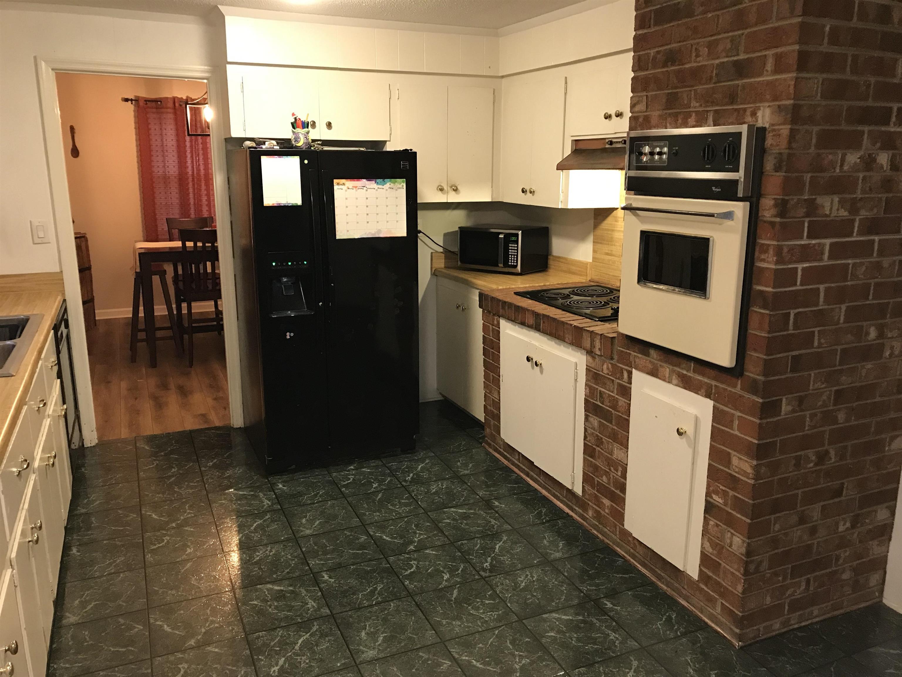 1201 Landgrave Street Georgetown, SC 29440 - Photo 16 of 38 Kitchen with black appliances, white cabinetry, and under cabinet range hood