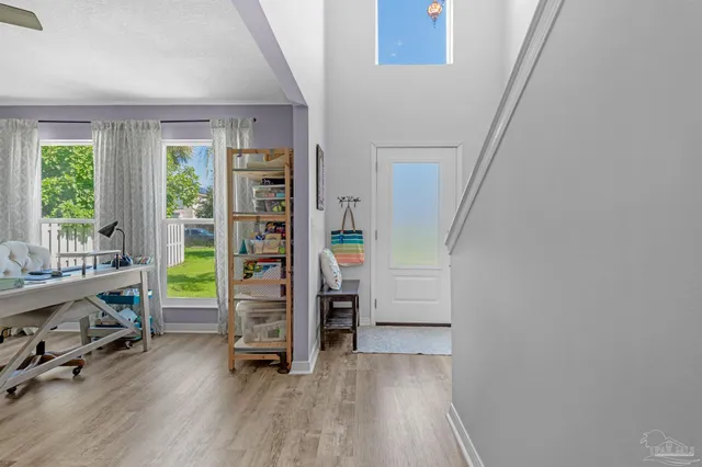 a kitchen with stainless steel appliances kitchen island granite countertop a refrigerator a stove top oven a sink a dining table and chairs with wooden floor