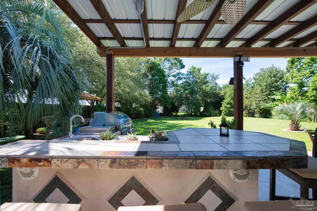 a view of porch with a table and chairs under an umbrella