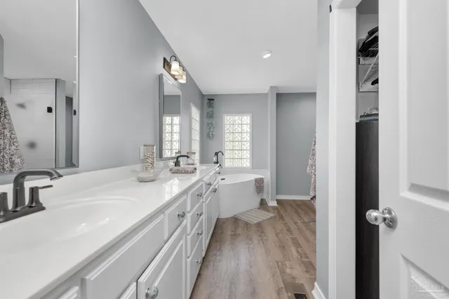 a bathroom with a bathtub a sink and a window
