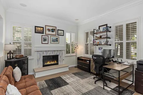 a living room with furniture a flat screen tv and a fireplace