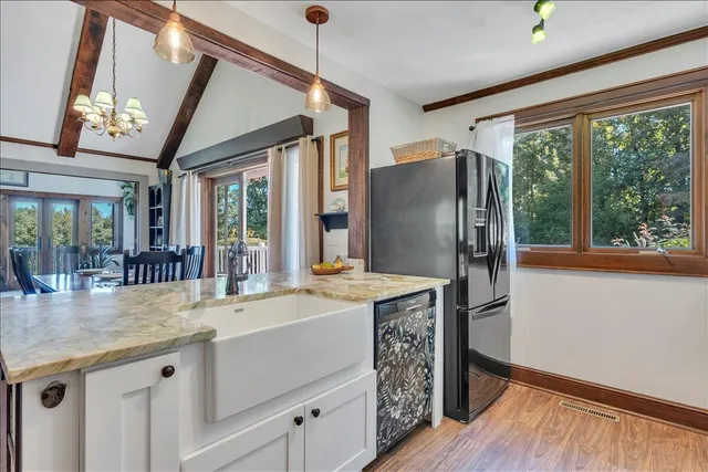 a kitchen with granite countertop white cabinets and stainless steel appliances