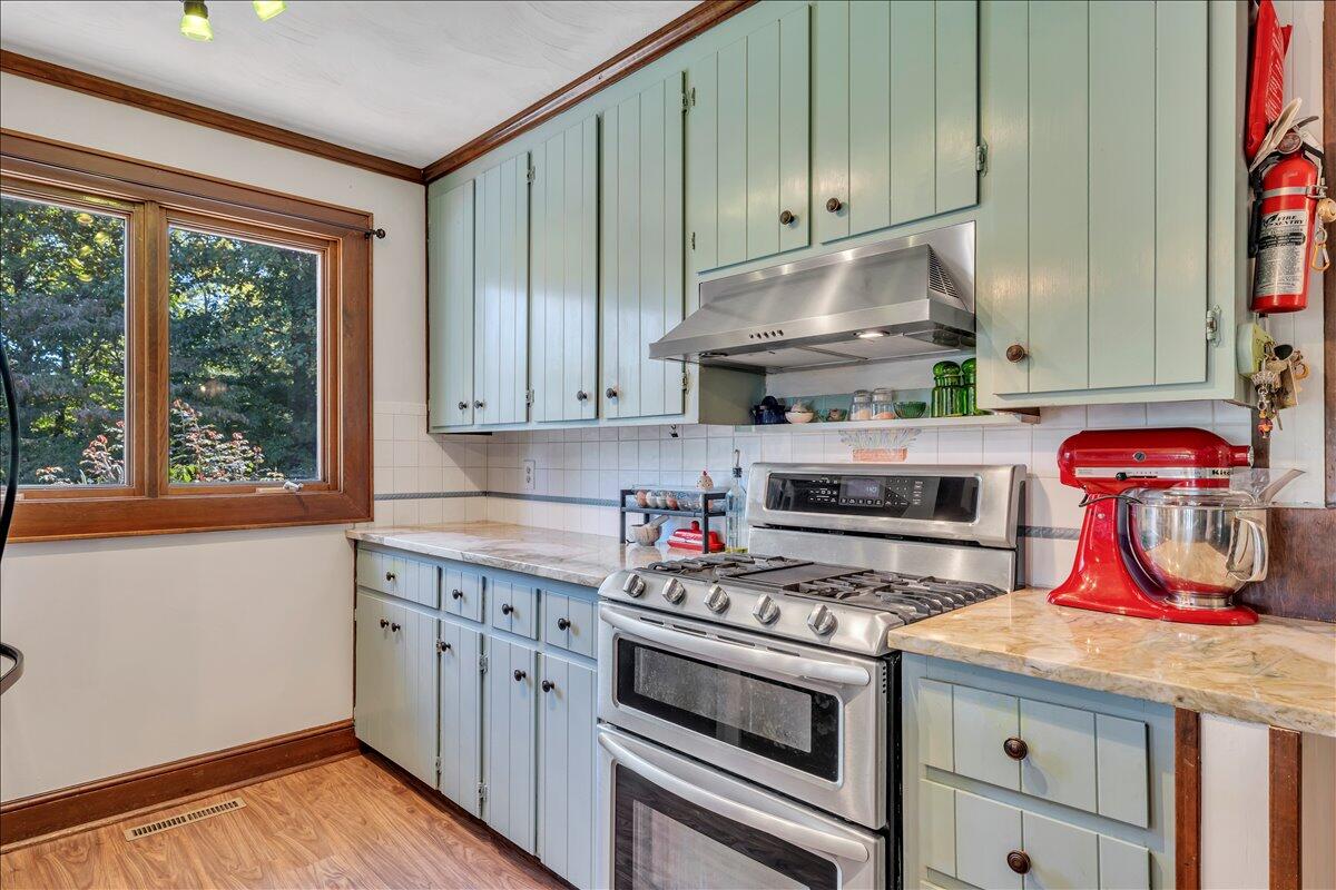 280 Woodwinds Road Callaway, VA 24067 - Photo 13 of 97 a kitchen with stainless steel appliances granite countertop a stove a microwave and wooden cabinets