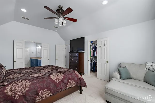 a spacious bedroom with a bed and ceiling fan
