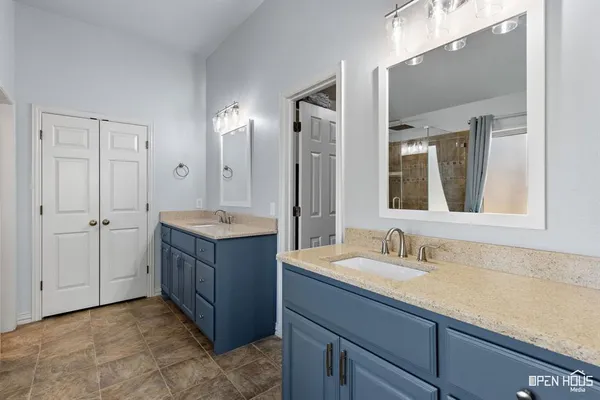 a bathroom with a sink vanity granite tub and a mirror