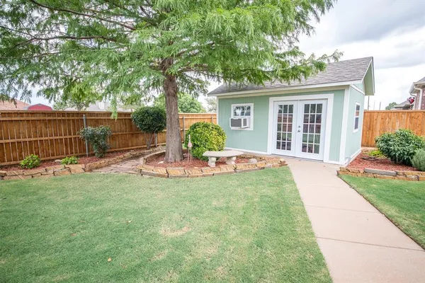 a view of a house with backyard and a tree