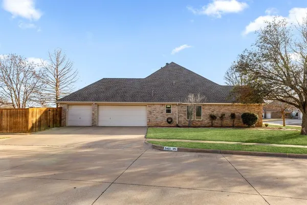 a front view of a house with a yard and trees