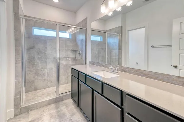 a bathroom with a shower sink and mirror