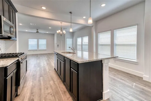 a kitchen with counter top space a sink appliances and cabinets