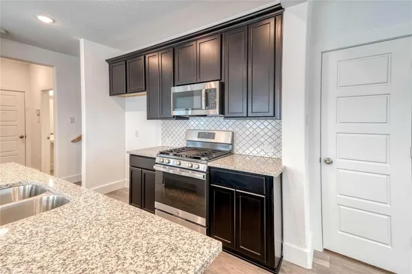 a kitchen with stainless steel appliances granite countertop a stove and a refrigerator