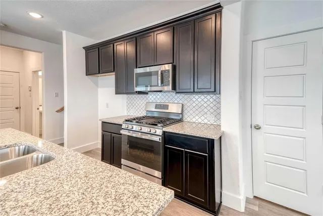 a kitchen with stainless steel appliances granite countertop a stove and a refrigerator