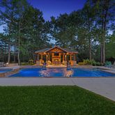 a view of playground with plants and large trees