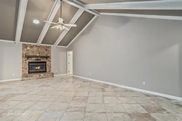 a view of an empty room with a fireplace and a window