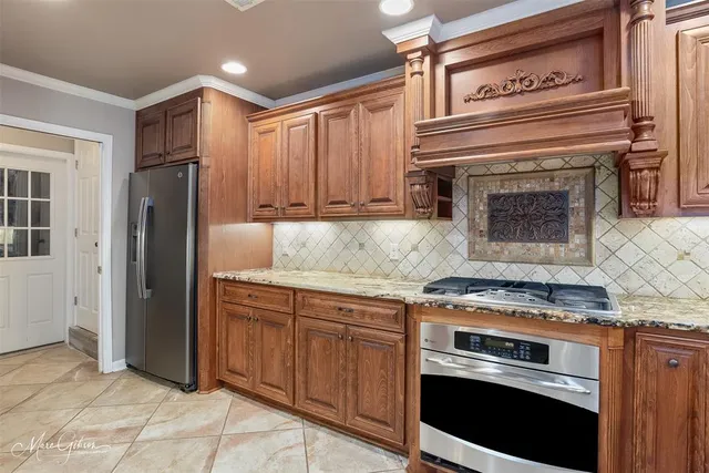 a kitchen with granite countertop a stove cabinets and stainless steel appliances
