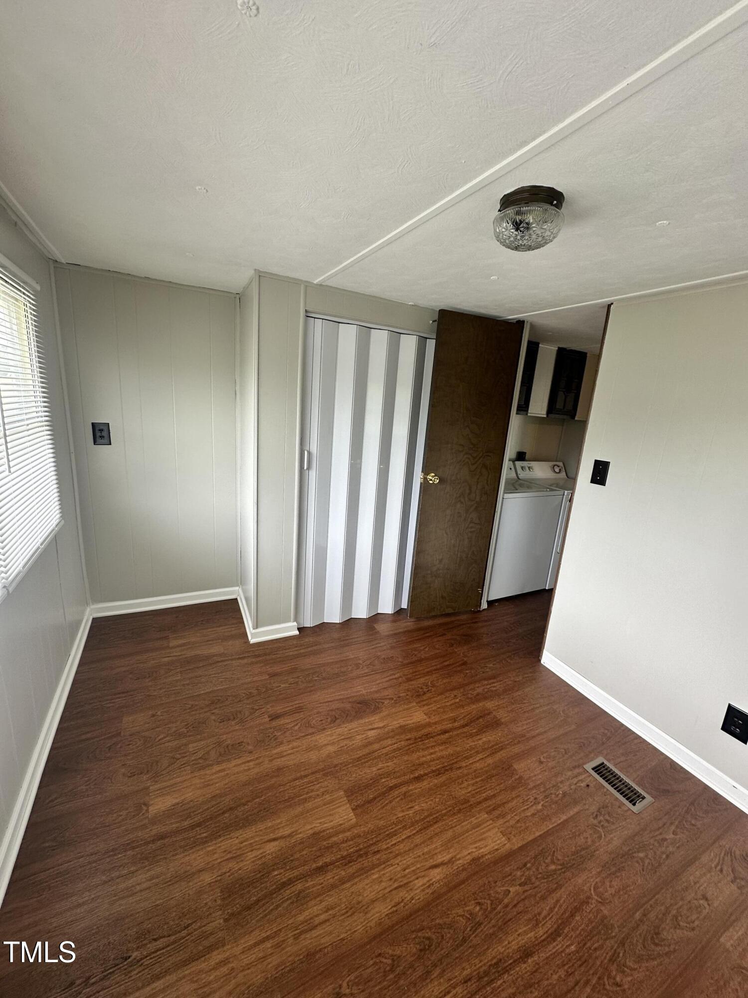 841 Chalybeate Springs Road Angier, NC 27501 - Photo 6 of 24 a view of an empty room with wooden floor and a window