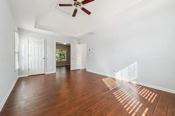 a view of an empty room with a window and wooden floor