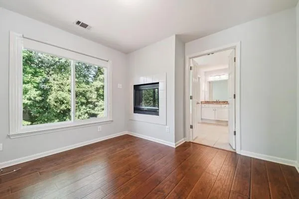 an empty room with wooden floor and windows